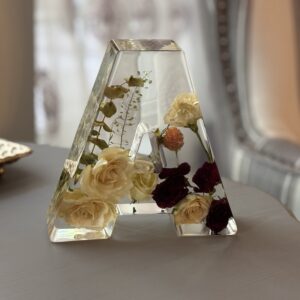 Resin artwork with preserved florals in the shape of a letter