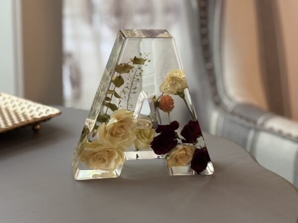 Resin artwork with preserved florals in the shape of a letter